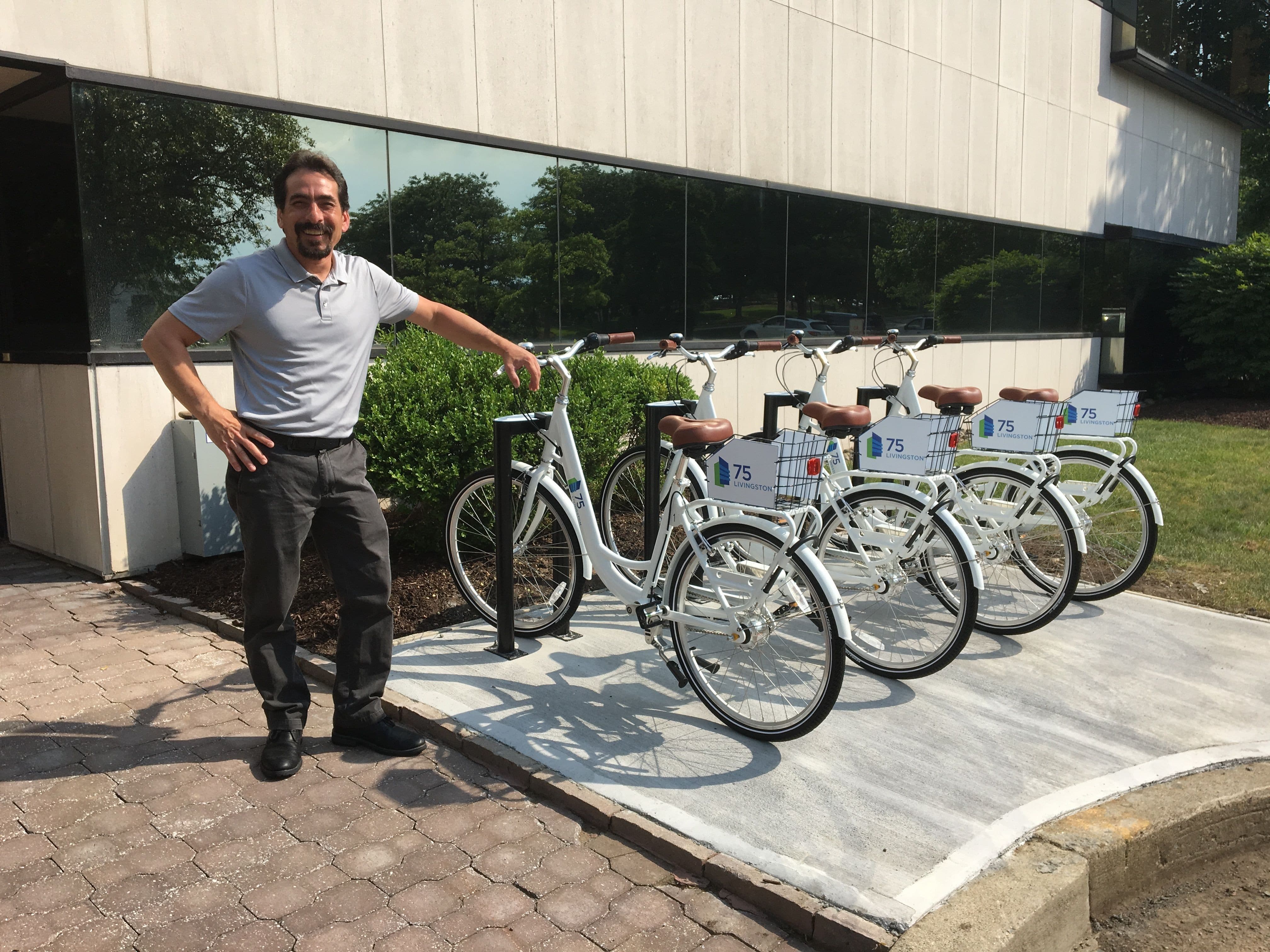 Bike share system owner standing with bikes at bike station. On Bike Share owners operate their own bike share programs.