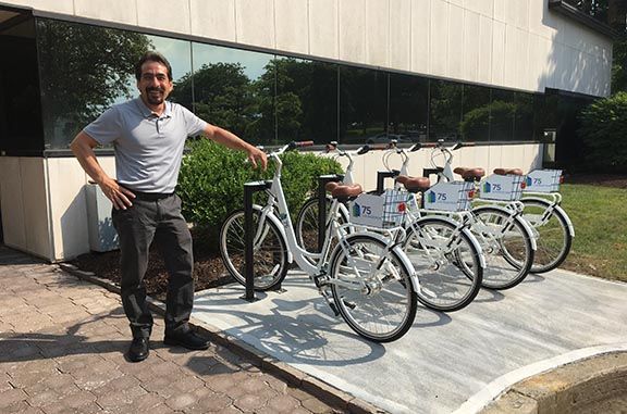 Property manager showing off bike share system at corporate office park