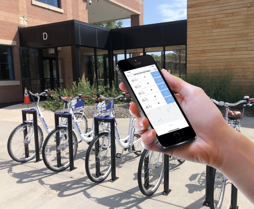 Couple riding On Bike Share bicycles with custom branding